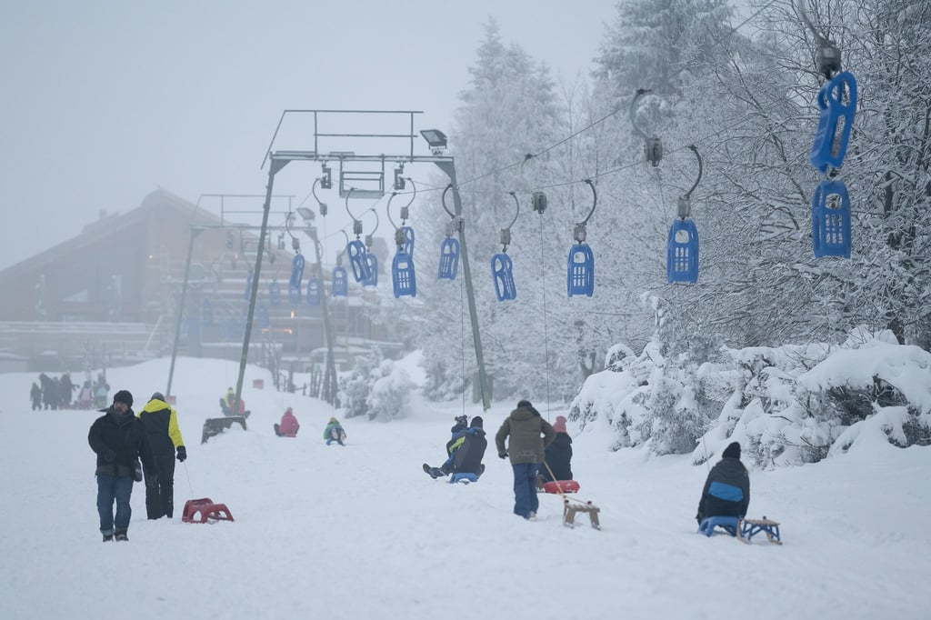 Wintersportler sind am Rodellift "Brockenblick" auf einer Schlittelpiste unterwegs.