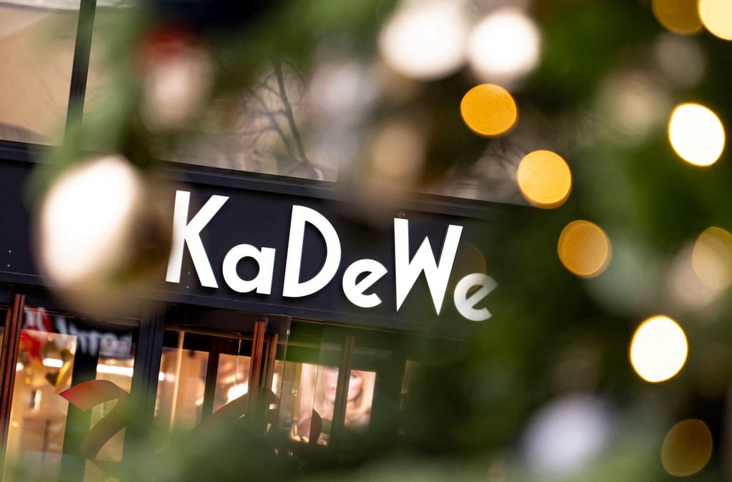 Das Logo des Kaufhaus des Westens (KaDeWe) hinter einem Weihnachtsbaum am verkaufsoffenen Sonntag.