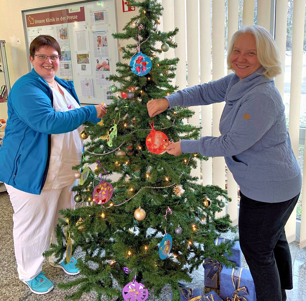 Monika Ölze (l.) und Monika Burda hängen die Wünsche an den Wunschweihnachtsbaum.