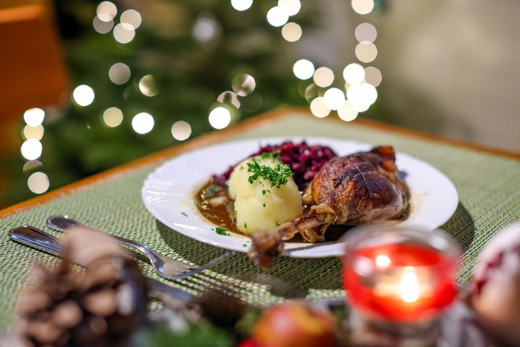 Eine Portion Gänsekeule mit Rotkraut und Klößen steht auf einem Tisch in einem Restaurant.