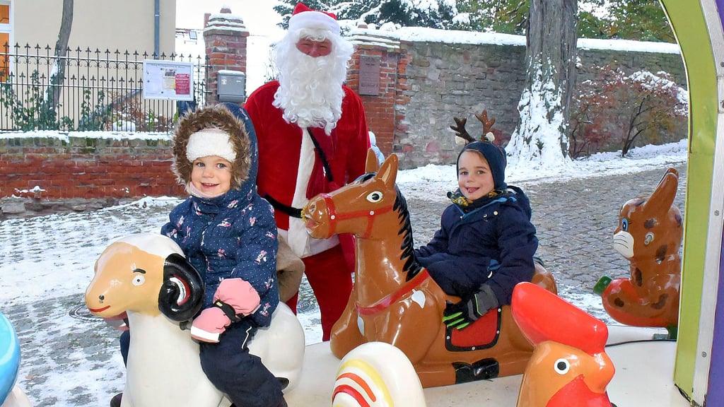 Die Geschwister Lina (links) und Louis haben mit ihren Eltern den Adventsmarkt in Könnern besucht und drehen eine Runde auf dem Karussell.