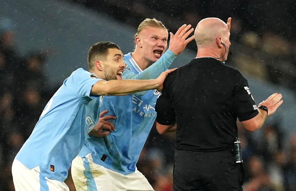 Die City-Spieler Erling Haaland (M) und Mateo Kovacic beschweren sich bei Schiedsrichter Simon Hooper.