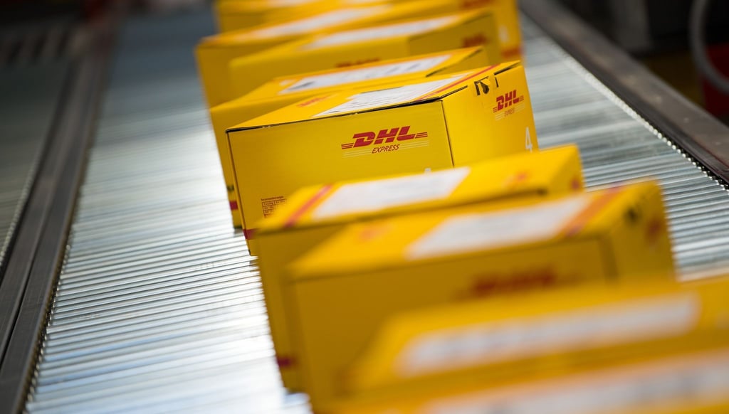Pakete liegen auf einem Förderband an einem DHL Express Logistikstandort.