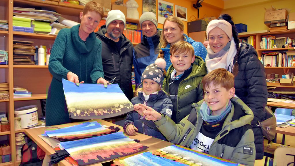 Kunstlehrerin Jutta Dietrich (l.) zeigt Bilder aus dem Unterricht. Zu den Gästen zählen Marcus (2.v.l.) und Jessika Bohnet (r.) aus Bülstringen mit der  fünfjährigen Tochter Romy und dem  elfjährigen Sohn Lenny. Fabian und Aline  Damm aus Bülstringen  sind die Eltern vom zehnjährigen Arne, der  mit Lenny die Calvörder Schule besucht.