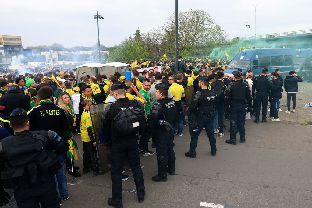 Polizisten stehen bei einer Gruppe von Fans des FC Nantes. Bei Zusammenstößen zwischen Fanlagern ist ein Fan ums Leben gekommen.