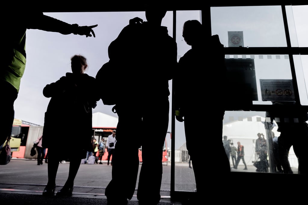Geflüchtete betreten die Empfangshalle des Ankunftszentrums Tegel.