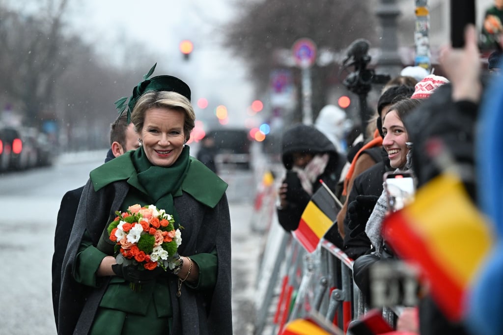 Königin Mathilde von Belgien wird von wartenden Zuschauern mit belgischen Fähnchen am Brandenburger Tor begrüßt.