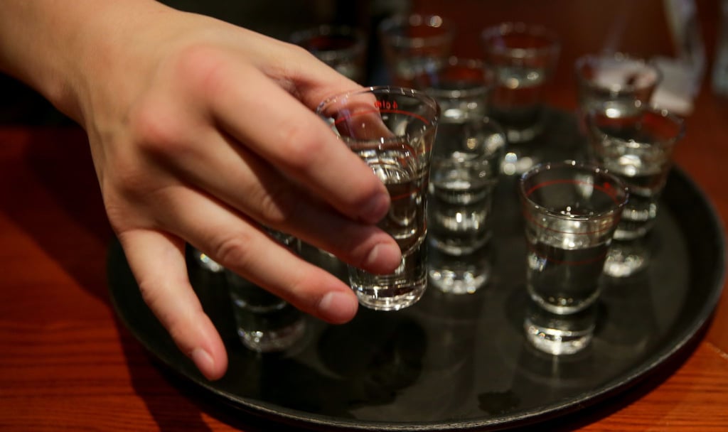 Eine Person greift nach einem gefüllten Schnapsglas. Mehr als zehn Millionen Menschen sterben laut der Weltgesundheitsorganisation (WHO) jedes Jahr durch Alkoholkonsum oder ungesunde Ernährung.