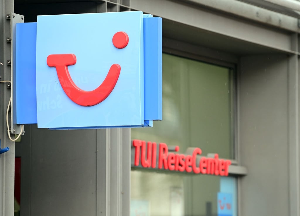Der Logo des Reiseveranstalters TUI hängt neben der Tür zu einem TUI ReiseCenter.