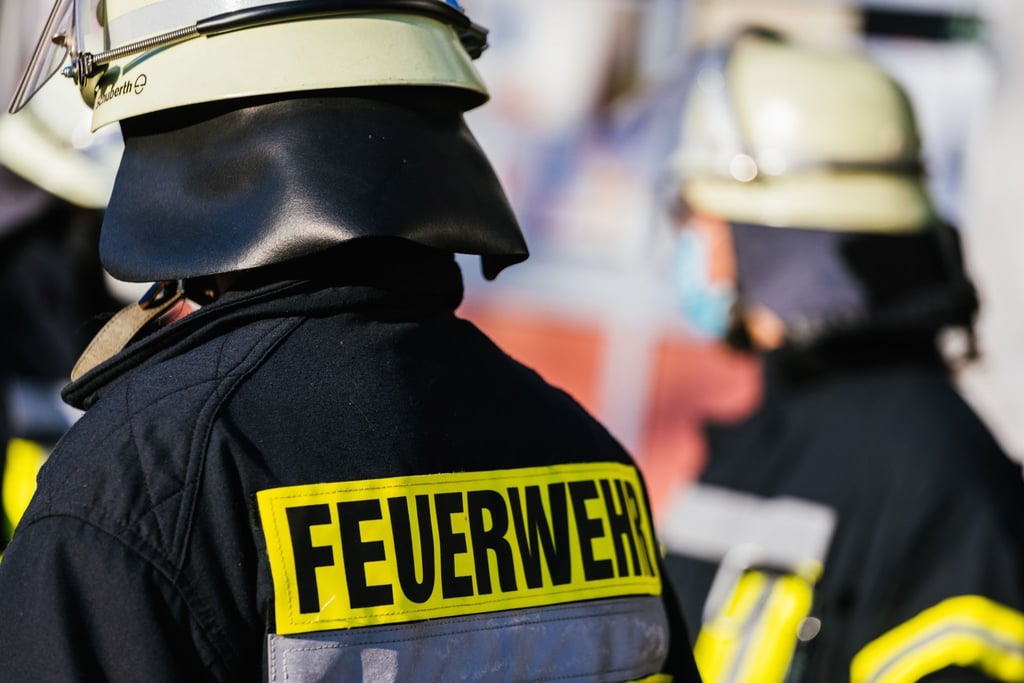 Einsatzkräfte der Feuerwehr in Schutzkleidung.