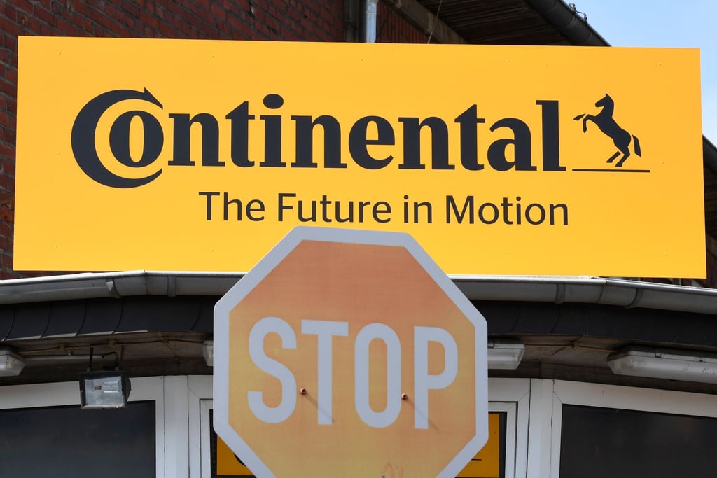 Blick auf das Logo des Reifenherstellers Continental und ein Stop-Schild während einer öffentlichen Informationsveranstaltung.