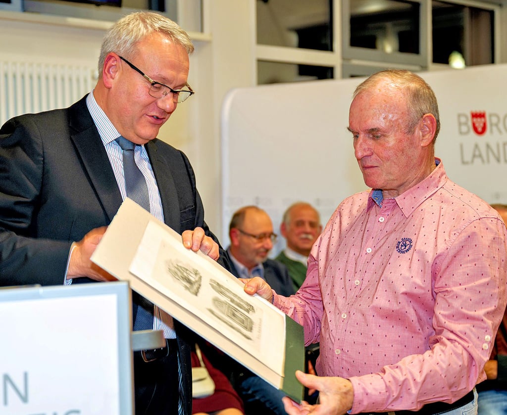 Landrat Götz Ulrich (links) überreicht Christoph Tandel eine Lithographie der Wehrkirche Treben, um deren Erhalt sich der Dehlitzer mit anderen Ehrenamtlern kümmert.