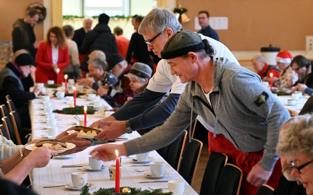 Helfer servieren eine warme Mahlzeit im Restaurant des Herzens der Evangelischen Stadtmission.