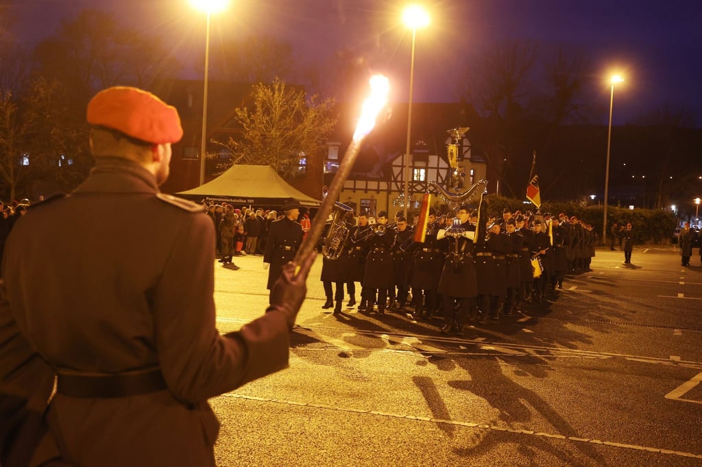 Ein Bundeswehrsoldat steht mit einer Fakel in der Hand beim Öffentlichen Gelöbnis.