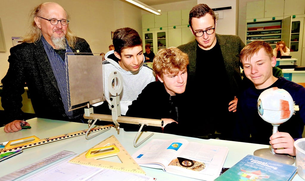 Torsten Wiehle (links) und Marco Thalmann (2. von rechts) schauen den Zehntklässlern Alexander Paschinski und Lennert Makowski aus Bernburg sowie William Nicolai (rechts) aus Könnern, die gemeinsam im Physikunterricht am Bernburger Gymnasium Carolinum lernen, über die Schulter.