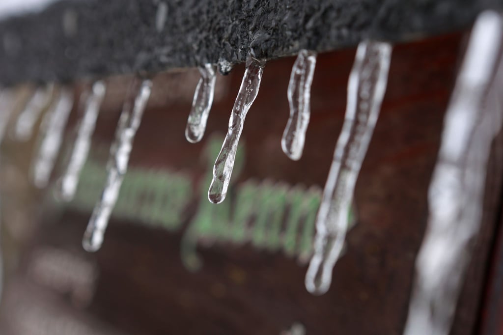 Eiszapfen hängen an einem Hinweisschild im Bereich Schierke.