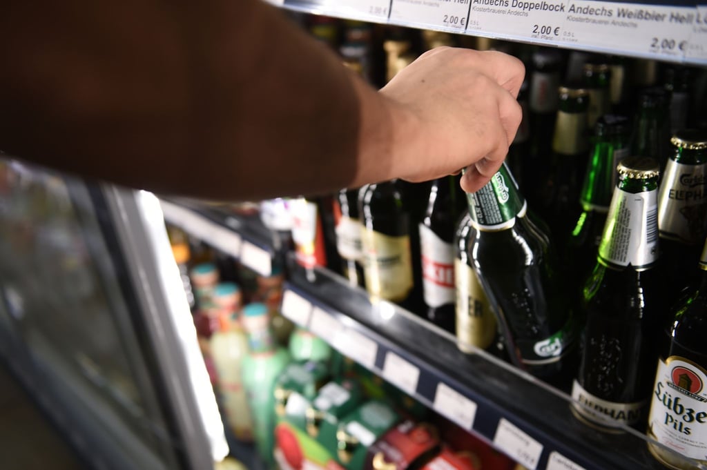 Ein Mann holt eine Flasche Bier aus einem Kühlschrank in einem Spätkauf in Berlin-Mitte.