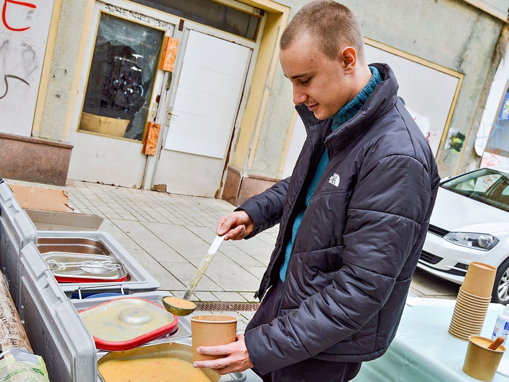 Eric Stehr und weitere Mitglieder der Initiative schenken bei der „Küche für alle“ Essen an Bedürftige aus.