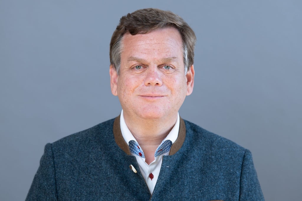 Alexander Räuscher steht anlässlich der konstituierenden Sitzung des Landtags vor einer Fotowand.