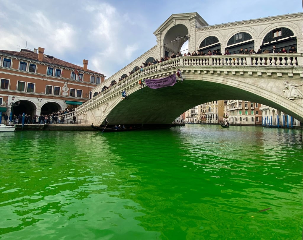 Das Wasser des Canal Grande unter der Rialto-Brücke in Venedig ist leuchtend grün gefärbt.