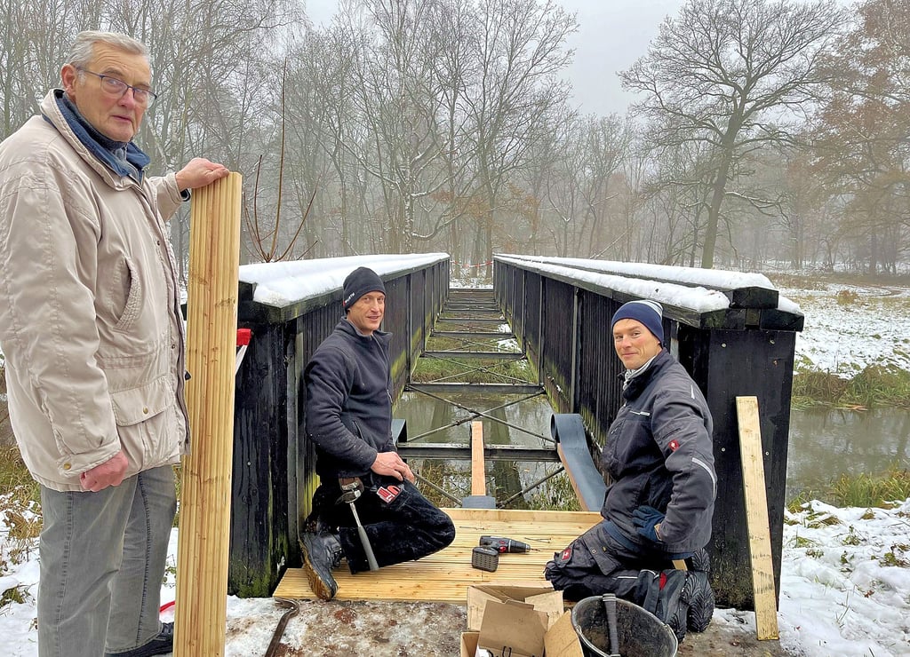 Die Brücke am Hohen Steg zwischen Tangerhütte, Briest und Weißewarte wird erneuert. Sebastian (von rechts) und Zimmerermeister Thomas Arndt erläutern Ortsbürgermeister Gerhard Borstell den Fortschritt.