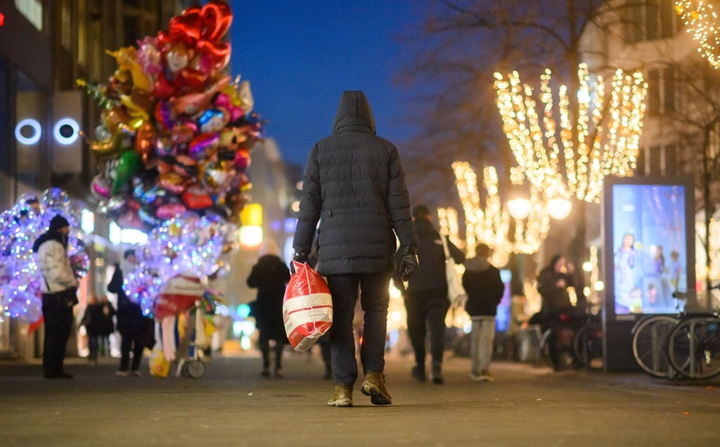 Ein Passant läuft mit einer Einkaufstasch durch die Innenstadt.