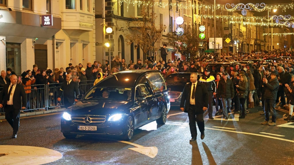 Der Leichenwagen mit dem Sarg von Shane MacGowan fährt nach seiner Beerdigung durch die Nenagh in Irland.