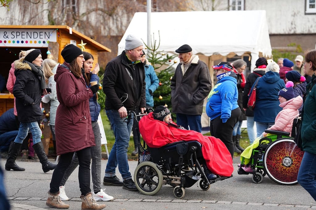 Besucherinnen und Besucher sind auf dem inklusiven Weihnachtsmarkt unterwegs.