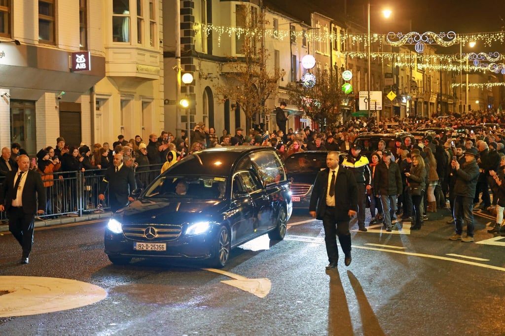 Der Leichenwagen mit dem Sarg von Shane MacGowan fährt nach seiner Beerdigung durch die Nenagh in Irland.
