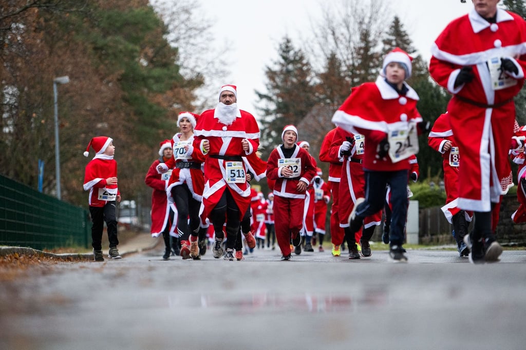 Teilnehmer laufen beim Nikolaus-Lauf mit Nikolaus Kostümen durch Michendorf.