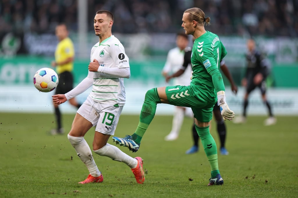 Der Fürther Tim Lemperle (l) kämpft mit Torwart Dominik Reimann aus Magdeburg um den Ball.