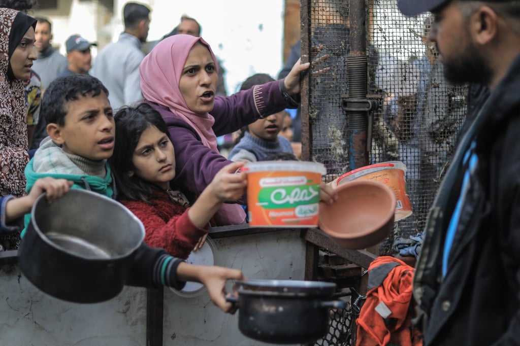 Menschen bitten an einer Essensausgabe in Rafah um Lebensmittel.
