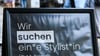 Auf einem Schild wird gendergerecht eine Stylistin beziehungsweise ein Stylist gesucht.