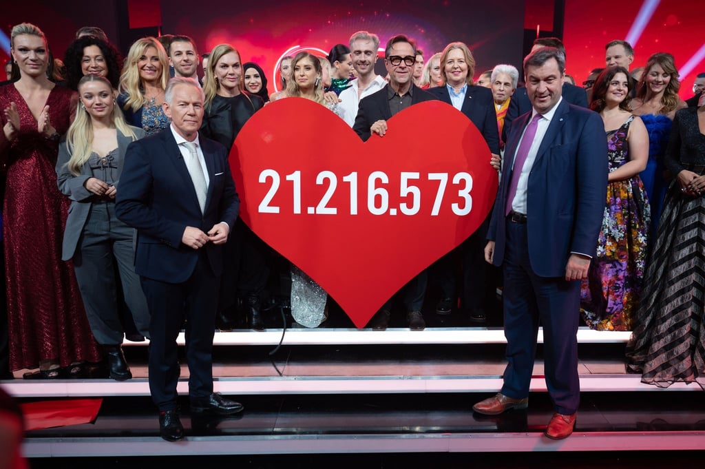 Moderator Johannes B. Kerner (l) und Markus Söder (CSU), Ministerpräsident von Bayern, während der TV-Spendengala "Ein Herz für Kinder" neben dem Herz mit der Spendensumme.