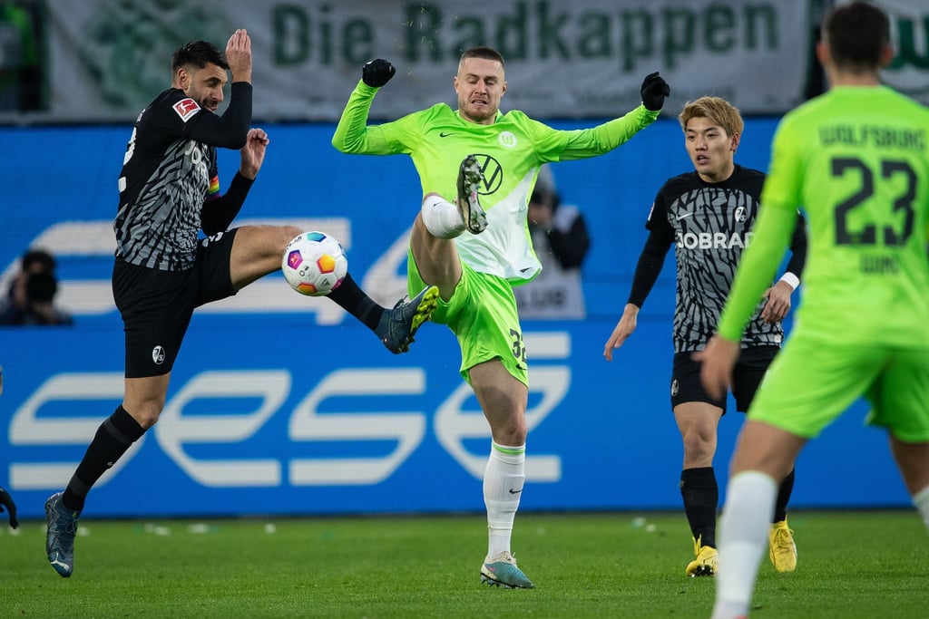 Wolfsburgs Mattias Svanberg im Zweikampf mit Freiburgs Vincenzo Grifo (l).