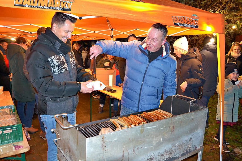 Sven Peters aus Osterweddingen (l.) und Matthias Strube aus Langenweddingen kümmern sich beim Adventsmarkt der Grundschule ums frisch Gegrillte.