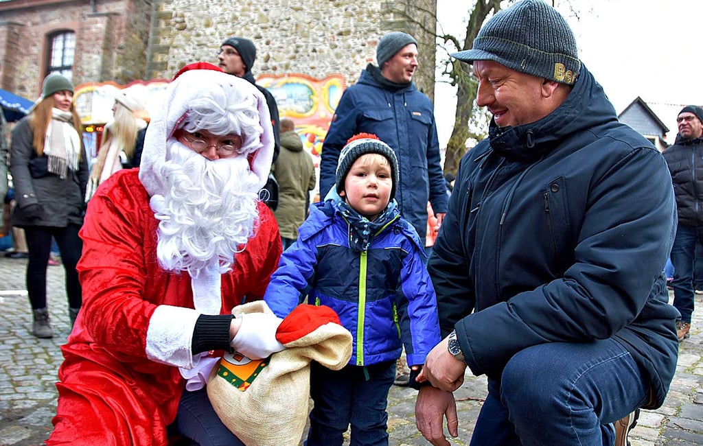 Der Weihnachtsmann hat ein Geschenk für den dreijährigen Joscha, der mit seinem Opa Frank Rödiger den bunten Budenzauber auf dem Marktplatz besucht.