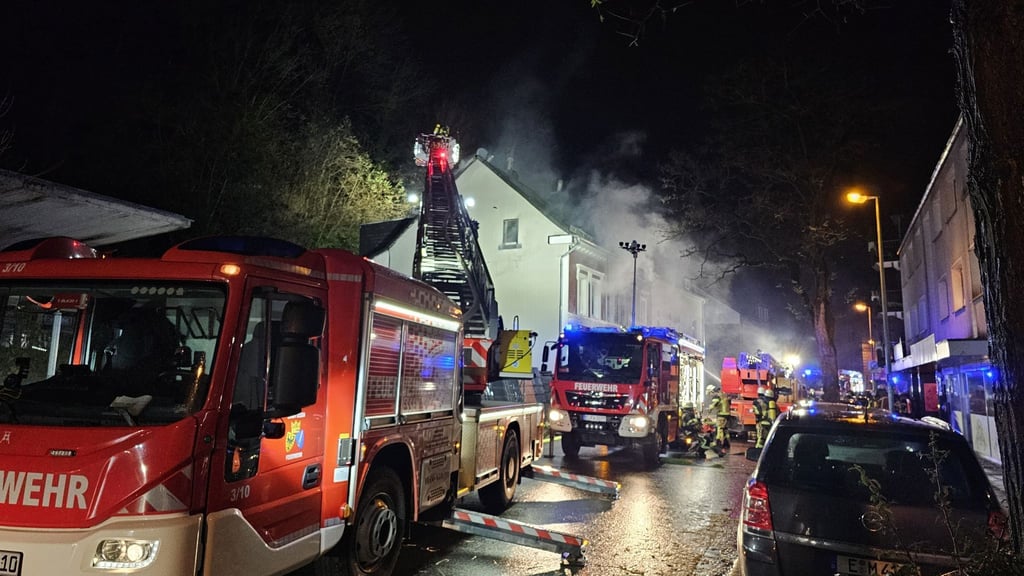 Feuerwehrleute löschen von einer Drehleiter aus.