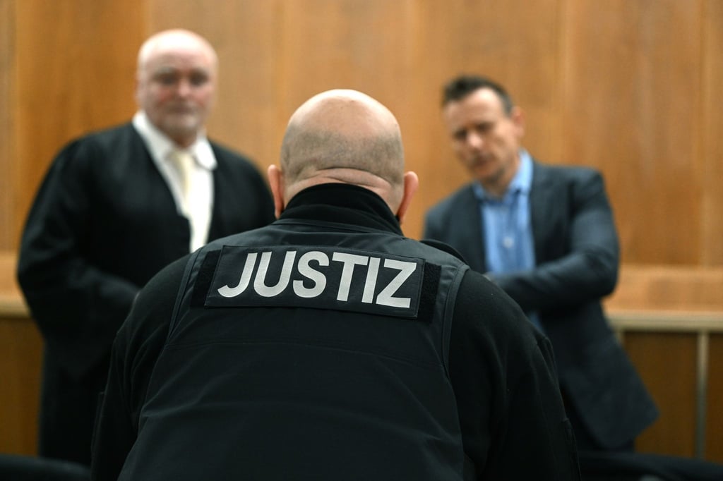 Ein Justizbeamter steht vor den Anwälten der Angeklagten.