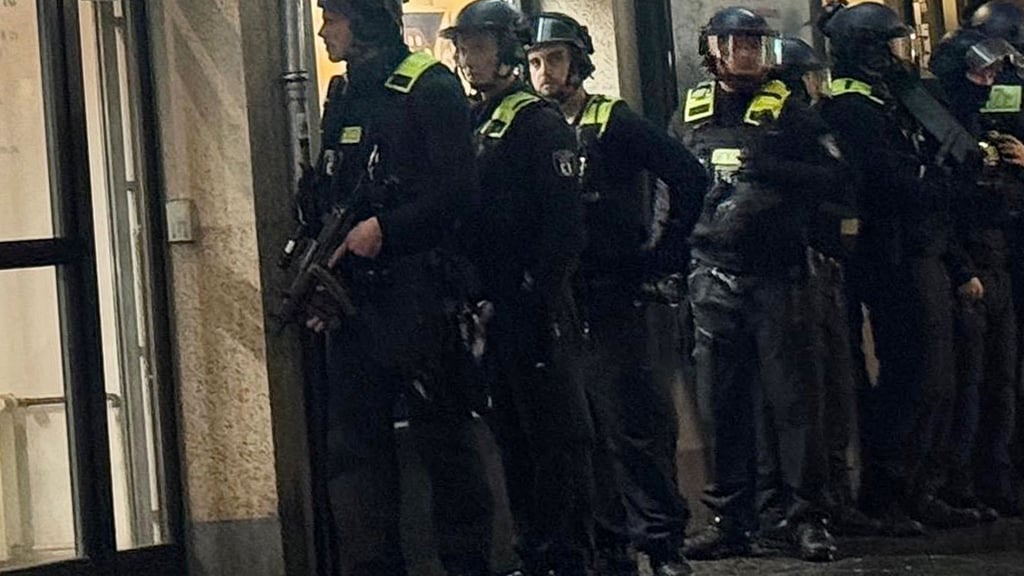 Polizisten stehen vor einem Münzgeschäft in Berlin-Friedrichshain, in dem am Montagnachmittag der Alarm ausgelöst worden war.