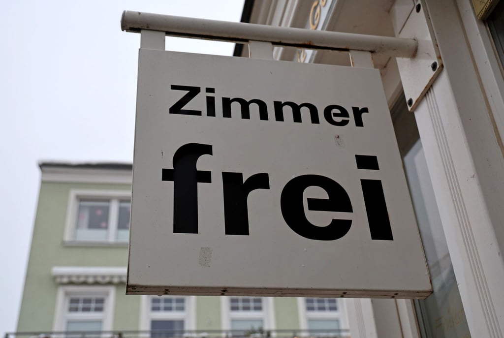 Ein Schild „Zimmer frei“ hängt an einem Hotel.