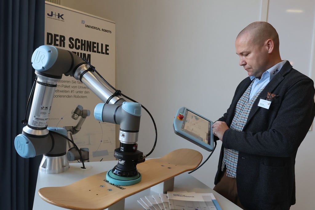 Christian Held von der Firma Jugard+Künstner arbeitet an einer Roboter Schleifmaschine.