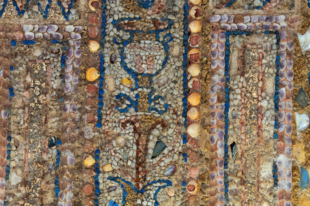 Mosaike aus Muscheln, Glas, winzigen Plättchen aus weißem Marmor und andere mehrfarbige Steine zieren die Wandbekleidung eines antiken römischen Stadthauses.