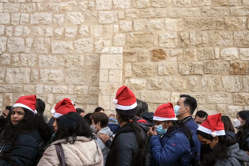 Heiligabend im vergangenen Jahr: Touristen - einige mit Weihnachtsmützen - stehen in Bethlehem vor der Geburtskirche Schlange.