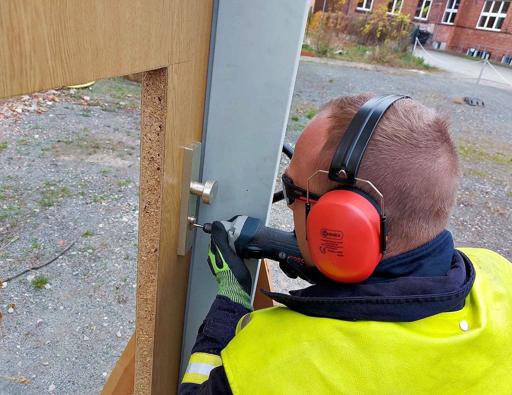 Ein Feuerwehrmann übt das Öffnen einer Wohnungstür.