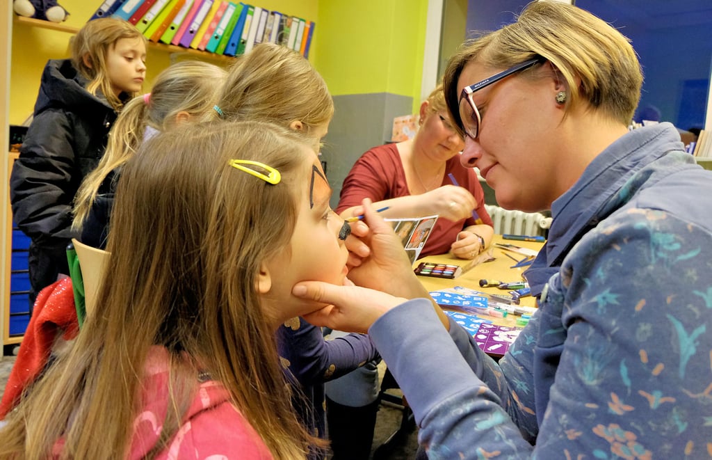 Christina Donath (rechts) verwandelt Leonie Fischer beim Kinderschminken wunschgemäß in ein Rentier.