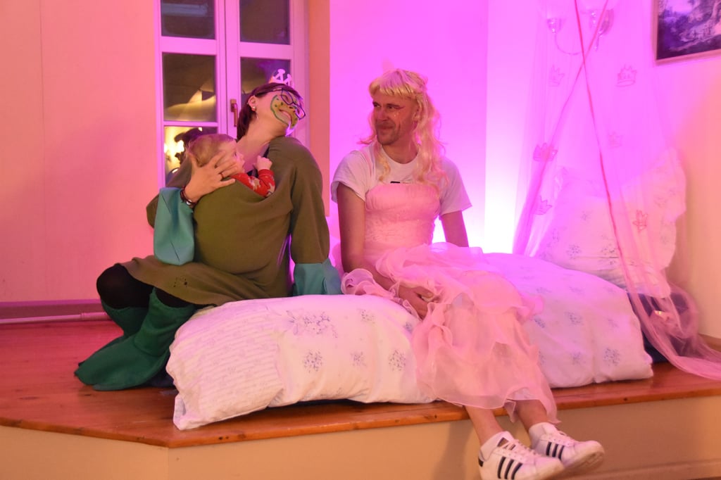 Der Frosch und sein Kind sitzen im Bett der Prinzessin.