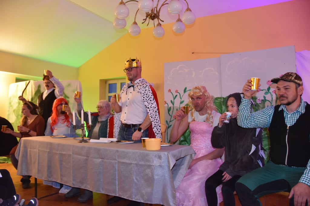 An einerlangen Tafel feiern die zauberhaften gestalten das zehnte Märchenstück in Velsdorf.