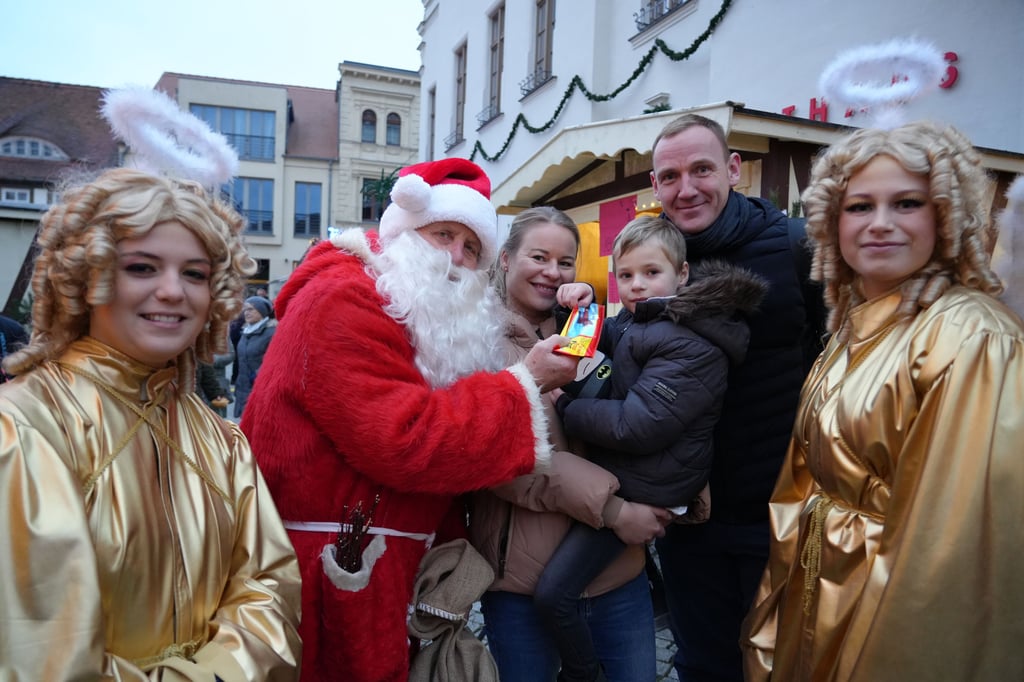Der Weihnachtsmann Hartmut Thomas und seine zwei Engel verteilen täglich Geschenke auf dem Weihnachtsmarkt in Stendal.