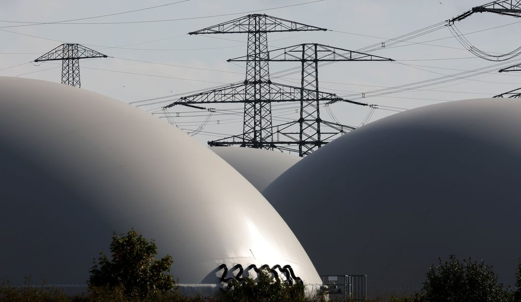 Hochspannungsmasten hinter den Speichern einer Biogasanlage.